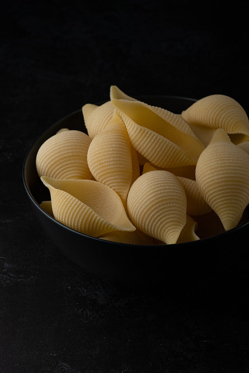 Conchiglie and orecchiette pasta showcasing their cup-like shapes